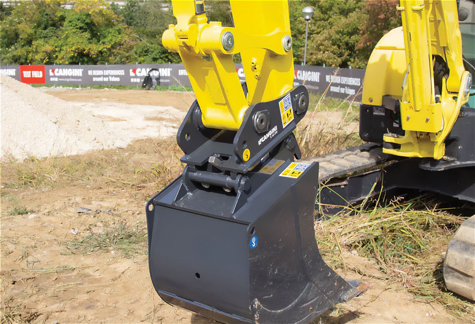 Attacco rapido montato su escavatore durante il cambio della benna in un contesto di cantiere.