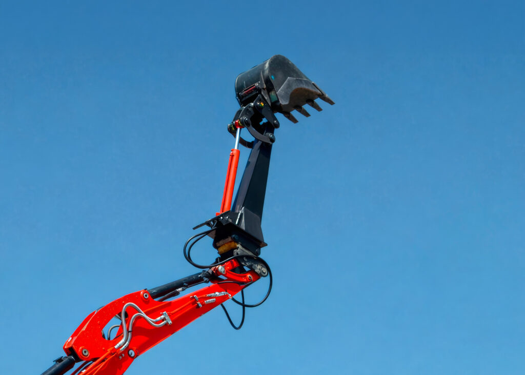Braccio prolunga installato su escavatore con benna da scavo sollevata contro il cielo.