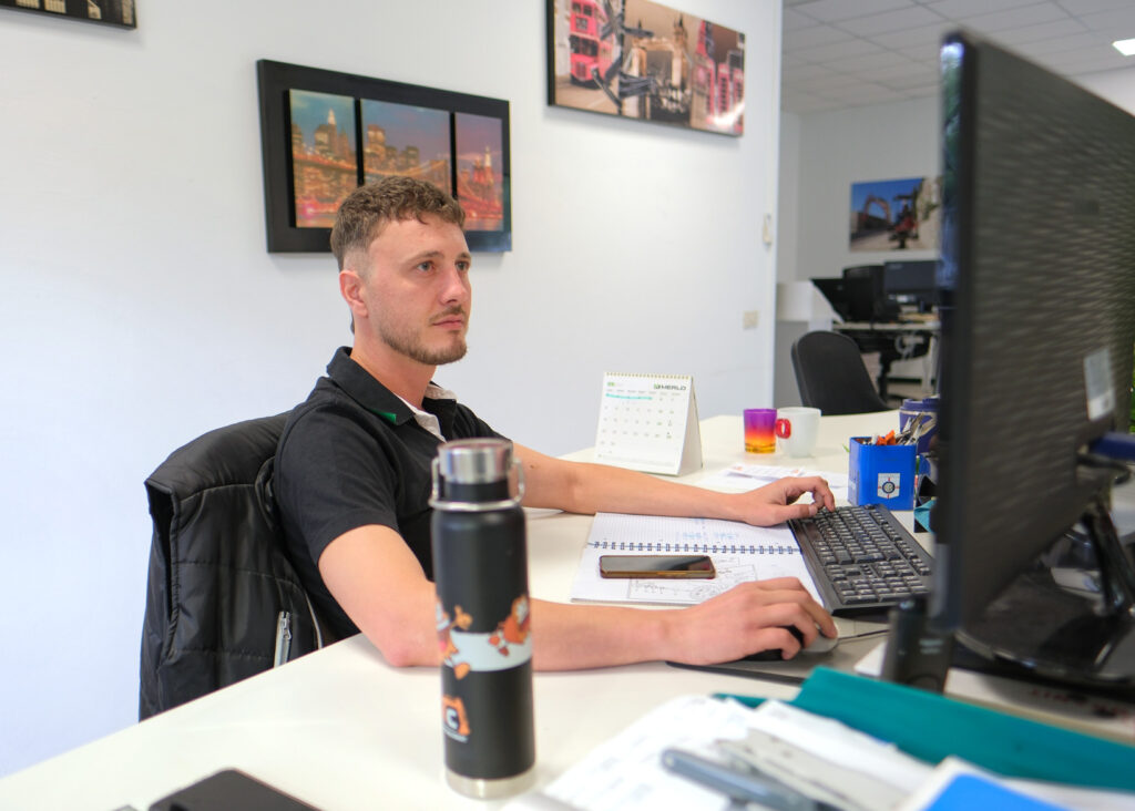 Alden Kurtisi al lavoro in ufficio davanti al computer nella sede RMC.