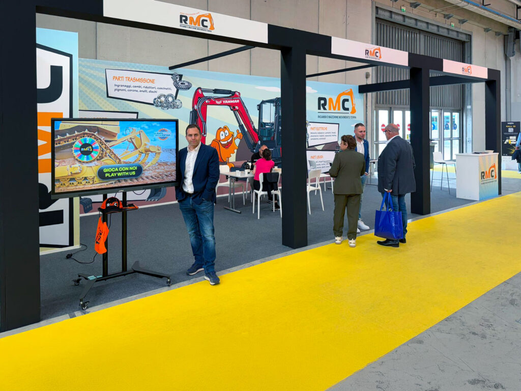 Stand RMC al SaMoTer 2026 con visitatori, area incontri e monitor dedicato alla ruota motrice della fortuna.