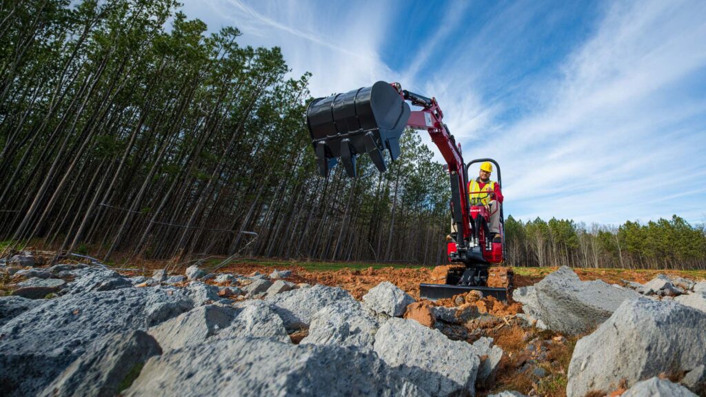 Miniescavatore Yanmar SV08-1C al lavoro in un cantiere con terreno roccioso e spazi ridotti, ideale per recupero edilizio e ristrutturazioni.