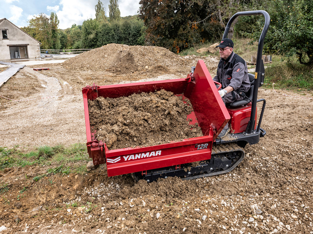 Dumper cingolato Yanmar C12R trasporta terreno durante le operazioni di movimentazione in un cantiere edile.