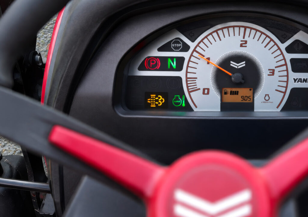 Spia del filtro antiparticolato DPF accesa sul quadro strumenti di un escavatore Stage V durante il monitoraggio del sistema motore.